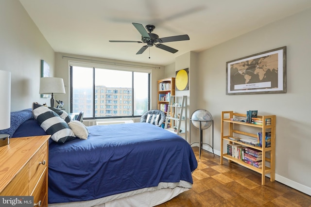 bedroom with a ceiling fan, baseboards, and wood finished floors