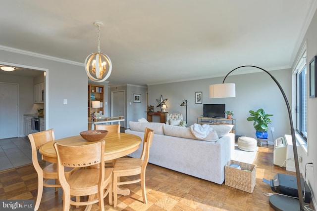 dining room featuring a wall unit AC, an inviting chandelier, baseboards, and crown molding