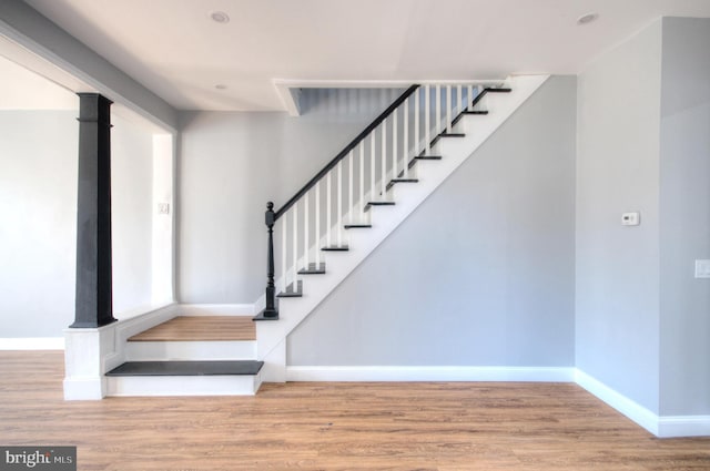 staircase featuring baseboards and wood finished floors