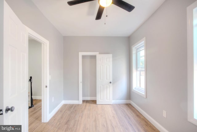 unfurnished bedroom featuring light wood-style flooring, baseboards, and a ceiling fan