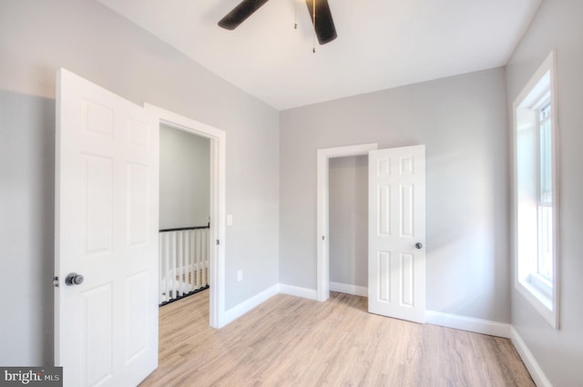 unfurnished bedroom featuring baseboards, ceiling fan, and light wood finished floors