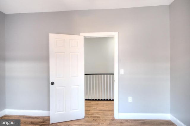 unfurnished room with light wood-type flooring and baseboards