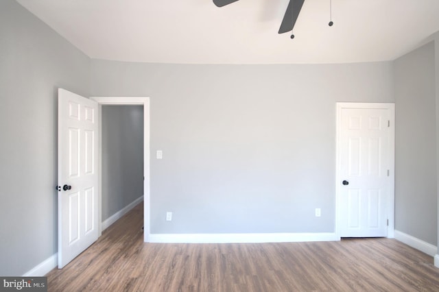 empty room featuring a ceiling fan, baseboards, and wood finished floors