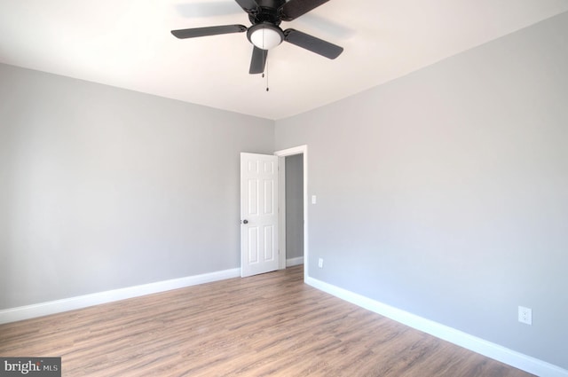 empty room featuring light wood-style floors, baseboards, and a ceiling fan