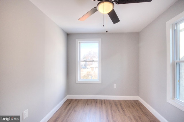 empty room featuring a ceiling fan, baseboards, and wood finished floors