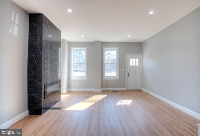 foyer entrance featuring light wood finished floors, a wealth of natural light, and baseboards