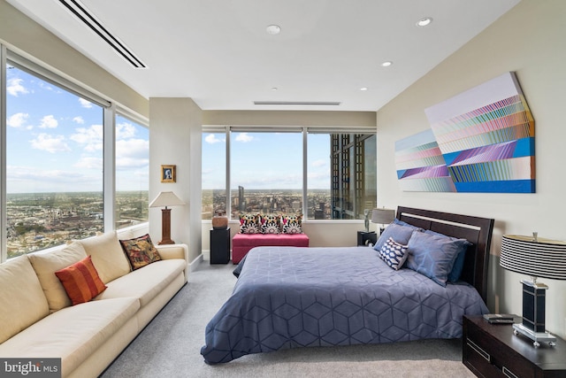 bedroom with recessed lighting, light carpet, and a city view