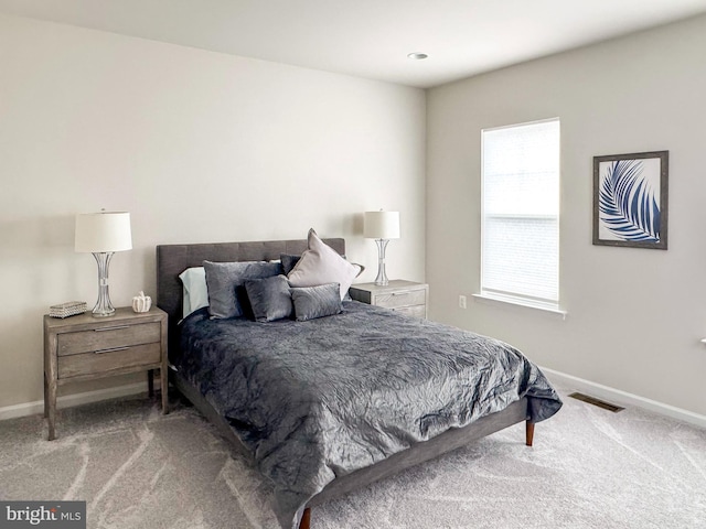 carpeted bedroom with visible vents and baseboards