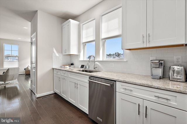 kitchen with dark wood-style flooring, white cabinetry, a sink, dishwasher, and baseboards