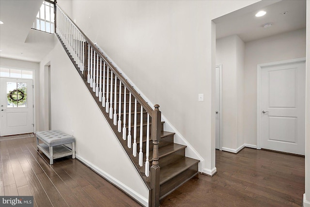 stairs with baseboards, wood finished floors, and recessed lighting