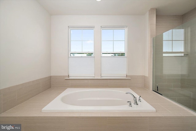 full bath featuring a garden tub and tiled shower