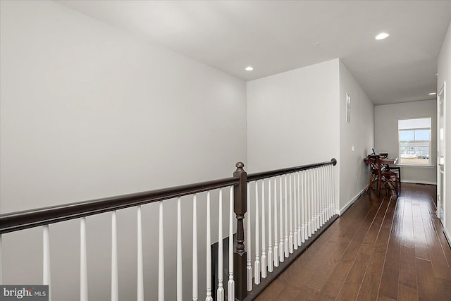 hallway with baseboards, hardwood / wood-style flooring, and recessed lighting