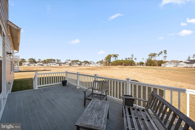 wooden terrace featuring a residential view and a lawn