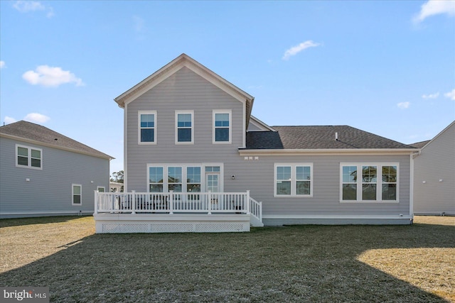 back of property featuring a yard, roof with shingles, and a wooden deck