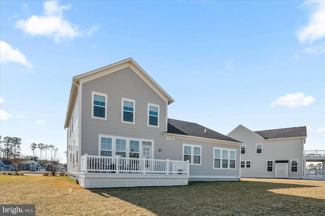 rear view of property featuring a deck and a yard