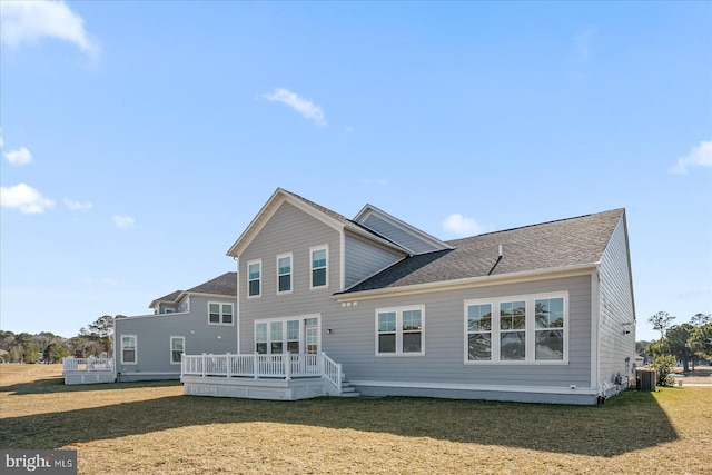 back of property with roof with shingles, a yard, a deck, and central AC unit