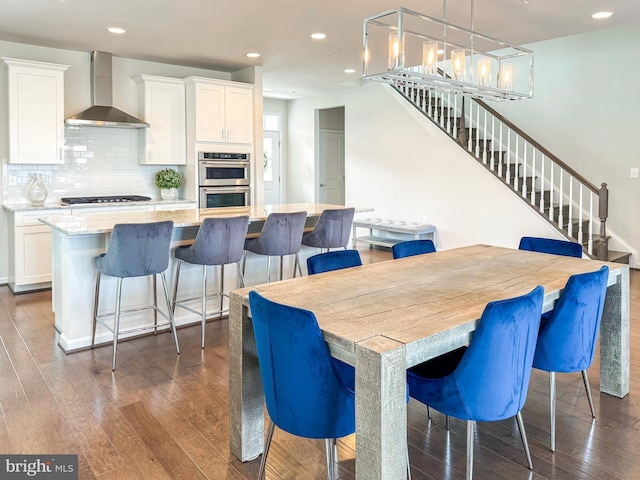 dining space featuring stairs, dark wood-style flooring, and recessed lighting