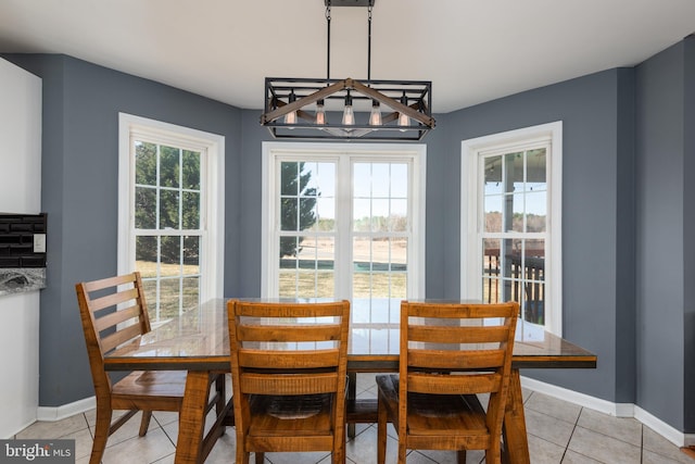 dining space featuring light tile patterned flooring and baseboards