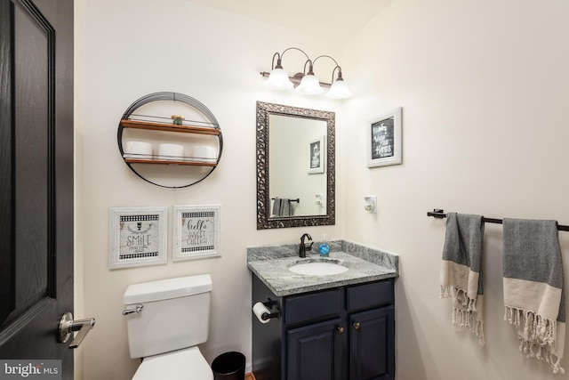 half bathroom featuring vanity and toilet