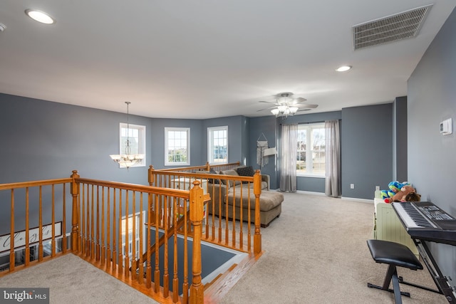 living room featuring a wealth of natural light, baseboards, visible vents, and carpet flooring