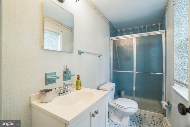 bathroom featuring toilet, vanity, baseboard heating, tile patterned floors, and a stall shower