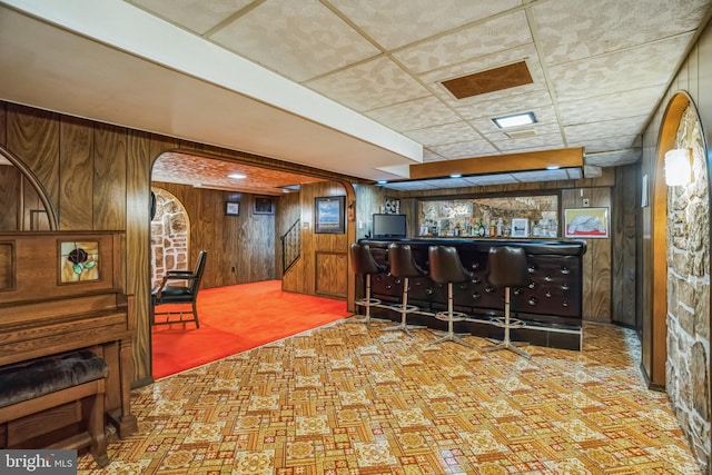 bar featuring arched walkways, wood walls, and a bar