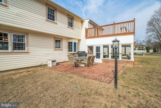 back of property with a lawn and a patio