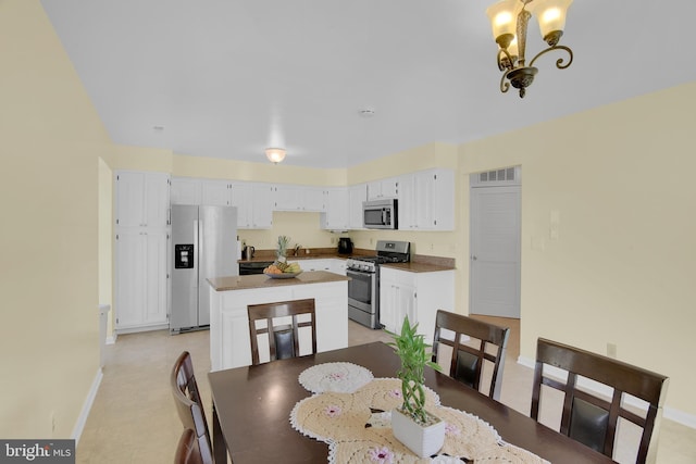 dining space with baseboards, visible vents, and a notable chandelier