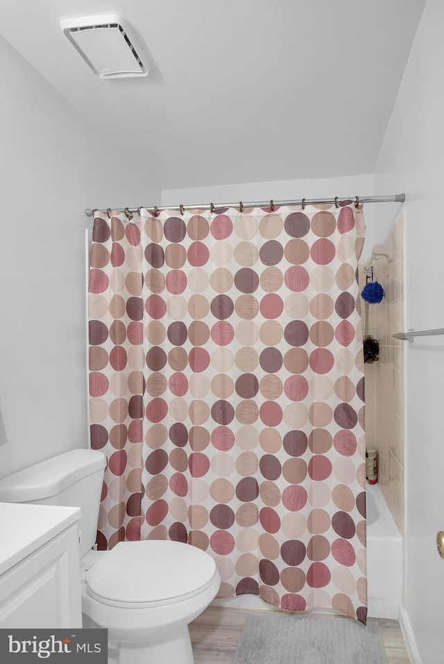 bathroom with toilet, wood finished floors, vanity, and visible vents