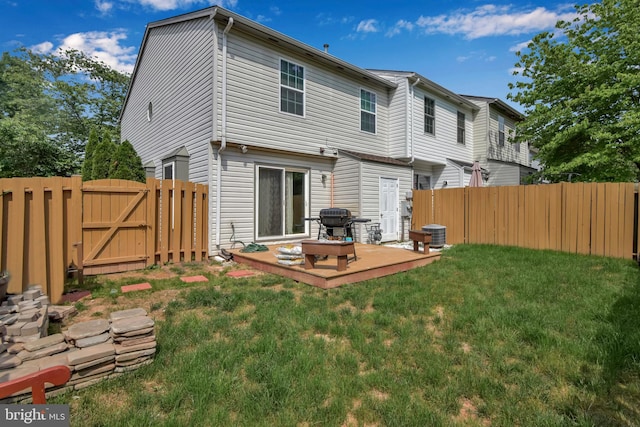 back of house with a gate, fence, and a lawn