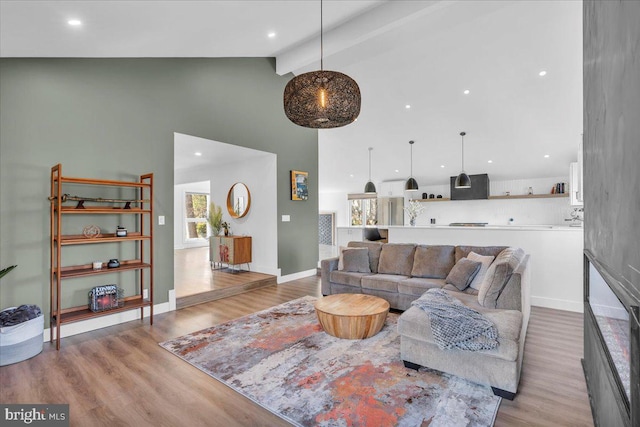 living room with high vaulted ceiling, beam ceiling, baseboards, and light wood finished floors