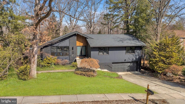 view of front of house with an attached garage, a front yard, concrete driveway, and brick siding