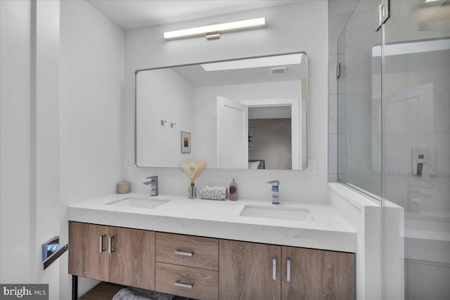 full bath with double vanity, a stall shower, and a sink