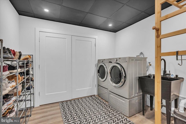 washroom with washer and dryer, laundry area, and light wood-style flooring