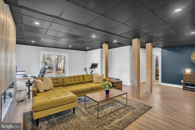 living area with recessed lighting, a drop ceiling, baseboards, and wood finished floors