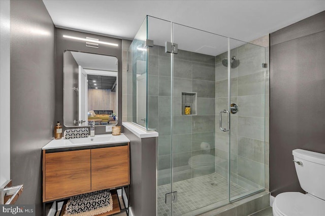 full bathroom with toilet, a shower stall, and vanity