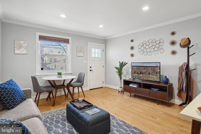 living area with ornamental molding, baseboards, and wood finished floors