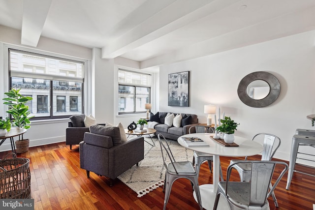 living area featuring beam ceiling, baseboards, and wood-type flooring