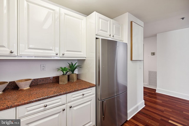 kitchen with white cabinets, dark wood-style floors, visible vents, and freestanding refrigerator