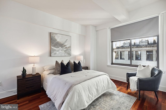 bedroom featuring beamed ceiling, baseboards, and hardwood / wood-style flooring