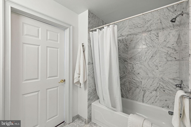 bathroom featuring shower / bathtub combination with curtain and marble finish floor