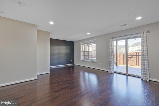 empty room featuring recessed lighting, wood finished floors, visible vents, and baseboards