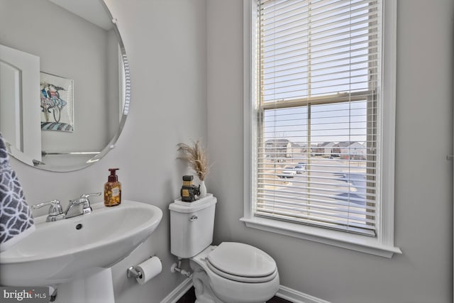 bathroom with toilet, baseboards, and a sink