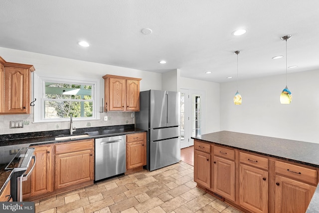 kitchen with recessed lighting, hanging light fixtures, backsplash, appliances with stainless steel finishes, and a sink