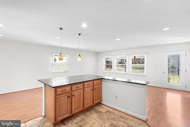 kitchen with hanging light fixtures, light wood-type flooring, a wealth of natural light, and recessed lighting