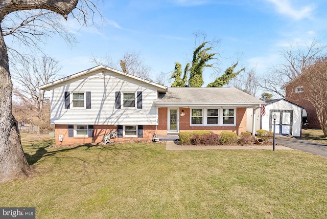 split level home with brick siding, aphalt driveway, an outbuilding, a shed, and a front yard