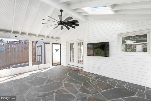 unfurnished sunroom with ceiling fan and lofted ceiling with skylight