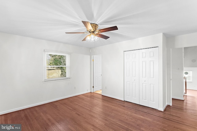 unfurnished bedroom with ceiling fan, a closet, baseboards, and wood finished floors