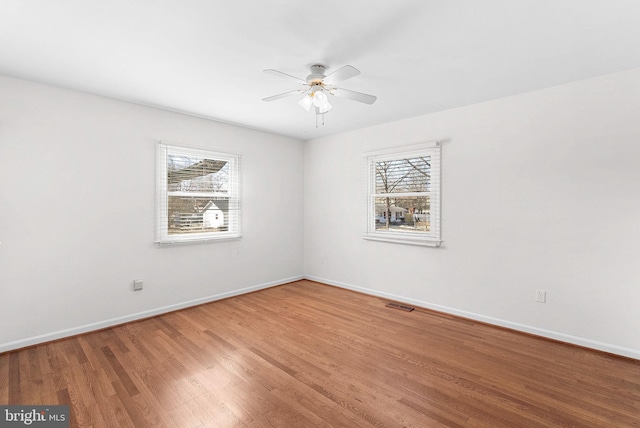 unfurnished room featuring baseboards, ceiling fan, visible vents, and light wood finished floors