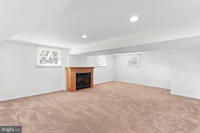 basement featuring carpet, plenty of natural light, baseboards, and recessed lighting